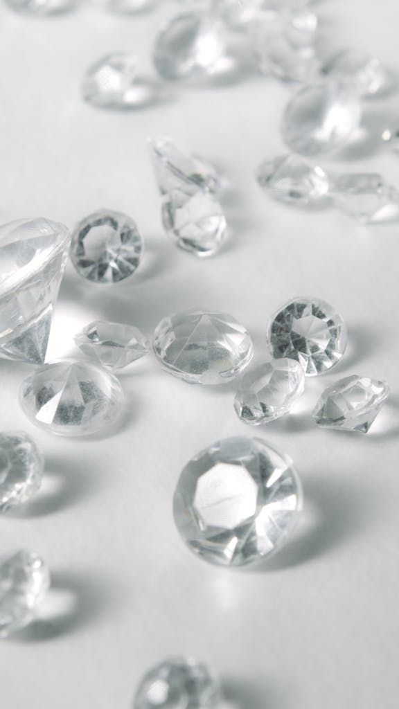A close-up of various clear-cut gemstones on a white surface, showcasing their sparkle and clarity.