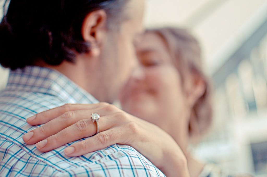Close-up of an engaged couple, highlighting a diamond ring, symbolizing love and commitment.